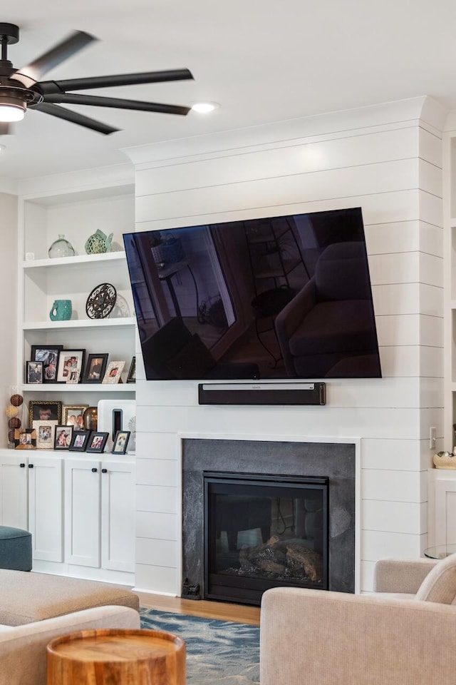 1903 Bolden Dr, Mount Pleasant, SC 29466 - living room featuring ceiling fan, a glass covered fireplace, wood finished floors, built in features, and crown molding