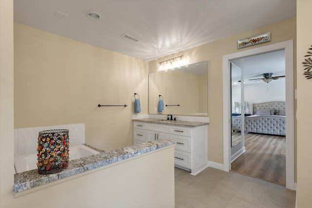 bathroom with vanity, a tub, tile patterned flooring, and a ceiling fan