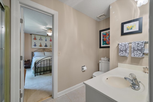 bathroom featuring a textured ceiling, baseboards, ceiling fan, vanity, and toilet