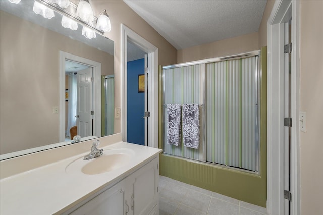 full bathroom featuring vanity, tile patterned floors, enclosed tub / shower combo, and a textured ceiling