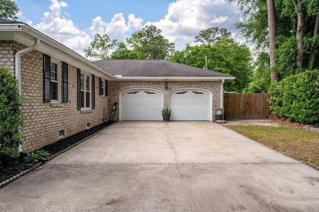 view of side of property with crawl space, a garage, driveway, and brick siding