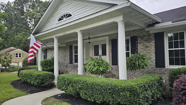 view of property exterior with brick siding and covered porch