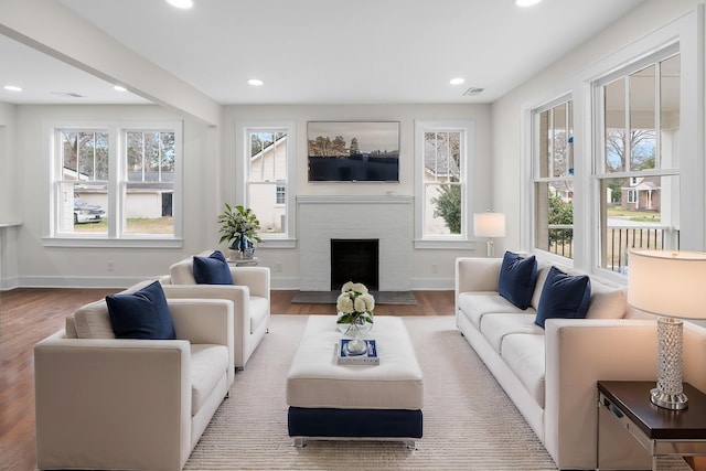 living room with wood-type flooring and a brick fireplace