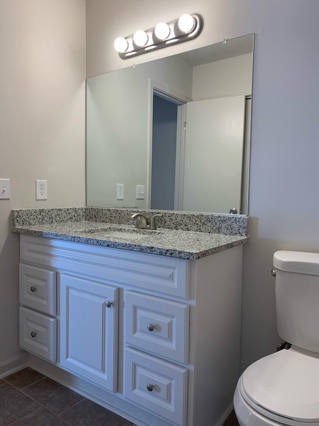 bathroom featuring tile patterned flooring, vanity, and toilet