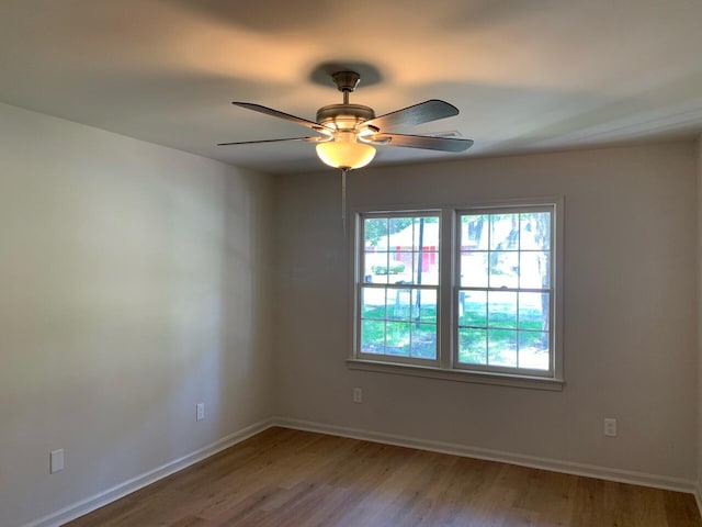 spare room with ceiling fan, baseboards, and wood finished floors