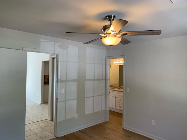 empty room featuring a ceiling fan and baseboards