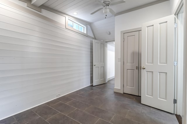 unfurnished bedroom featuring ceiling fan and dark tile floors