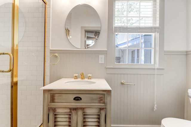 bathroom with walk in shower, vanity, and toilet