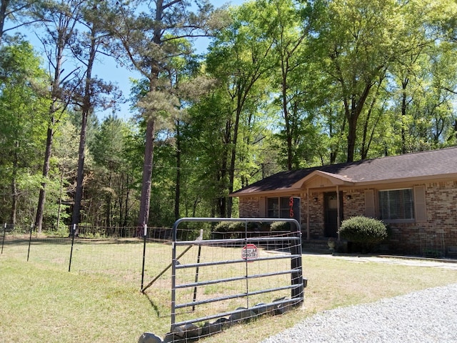 view of front of property with a gate, fence, a shingled roof, a front lawn, and brick siding