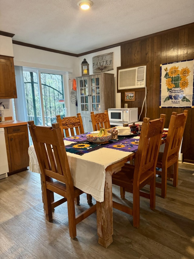 dining space featuring ornamental molding, a textured ceiling, and wood finished floors