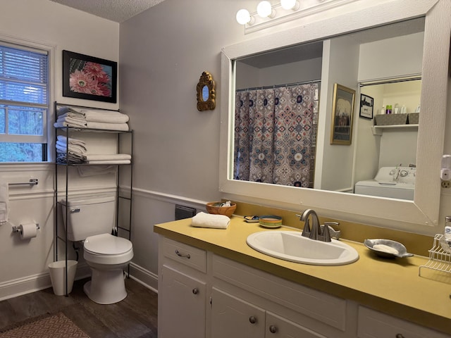 bathroom with vanity, wood finished floors, washer / dryer, a textured ceiling, and toilet