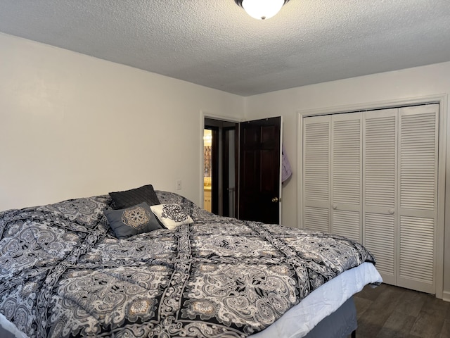 bedroom with dark wood-type flooring, a closet, and a textured ceiling