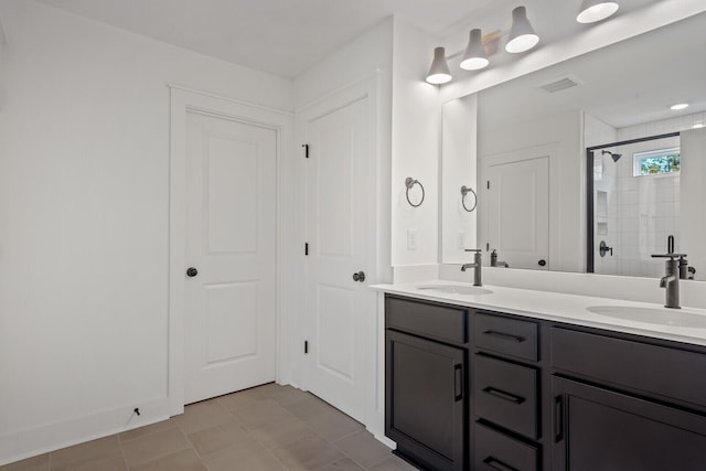 bathroom with tile patterned flooring, vanity, and walk in shower