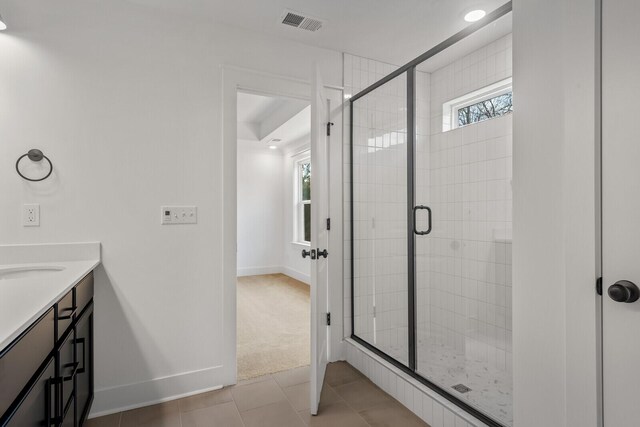 bathroom with tile patterned floors, an enclosed shower, and vanity