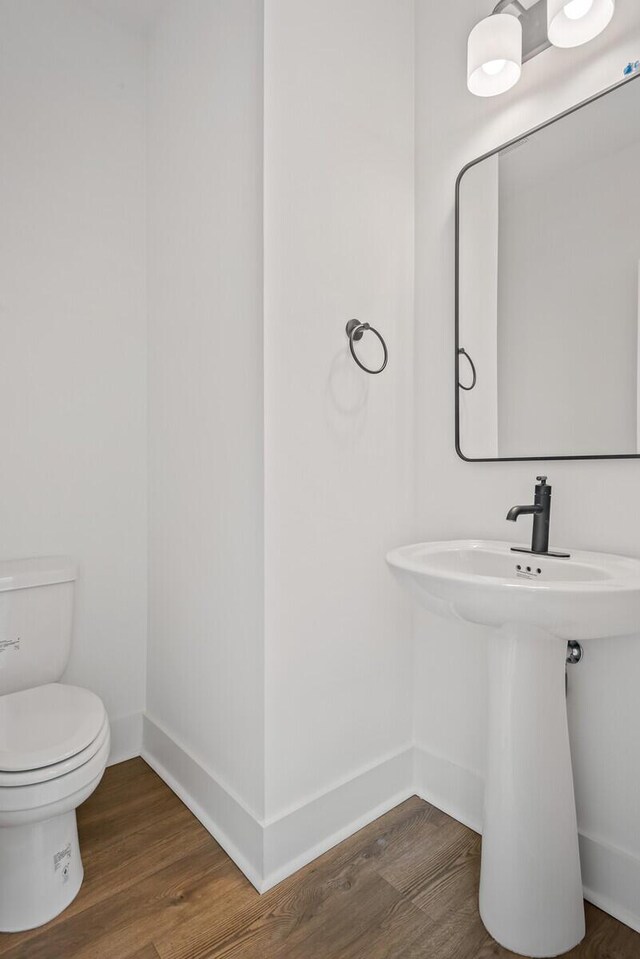 bathroom with wood-type flooring and toilet