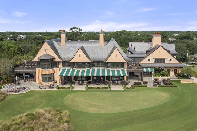 6002 Green Dolphin Way, Kiawah Island, SC 29455 - back of house featuring a chimney, view of golf course, and a yard