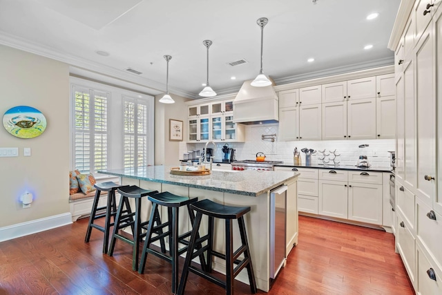 6002 Green Dolphin Way, Kiawah Island, SC 29455 - kitchen with tasteful backsplash, premium range hood, ornamental molding, white cabinets, and glass insert cabinets