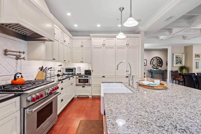 6002 Green Dolphin Way, Kiawah Island, SC 29455 - kitchen with luxury range, custom exhaust hood, a sink, white cabinetry, and recessed lighting