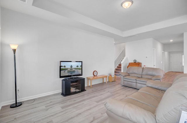 living room featuring stairway, light wood-style flooring, baseboards, and recessed lighting