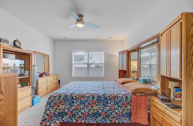 bedroom featuring multiple windows, carpet flooring, and a ceiling fan
