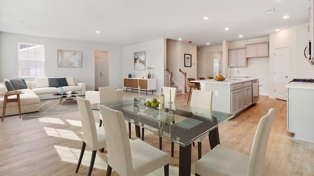 dining space with light hardwood / wood-style floors and sink