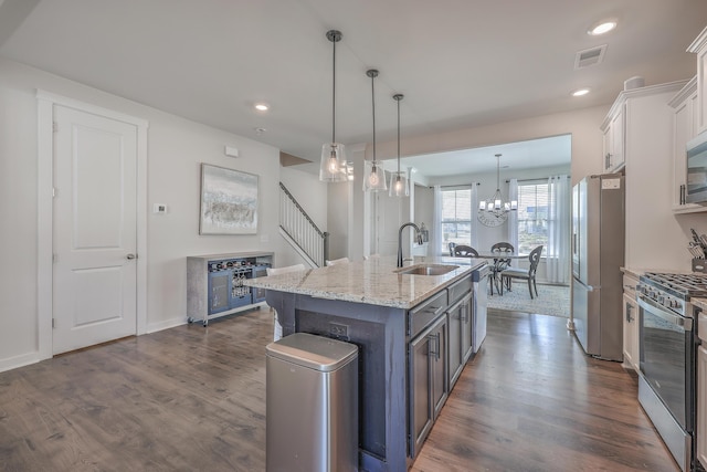 kitchen featuring visible vents, white cabinets, an island with sink, appliances with stainless steel finishes, and a sink