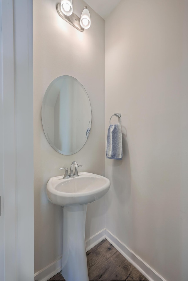 bathroom with wood finished floors and baseboards