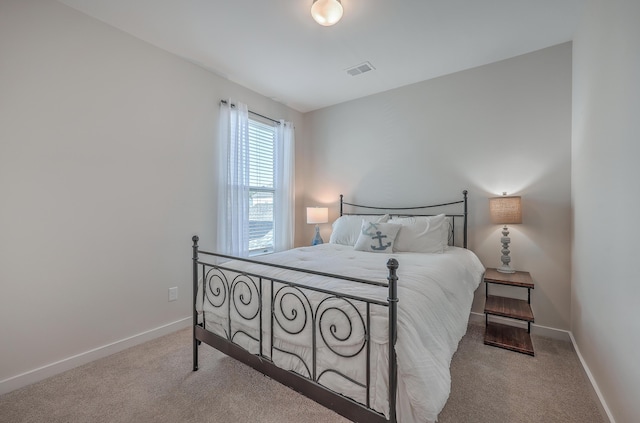 bedroom with light colored carpet, visible vents, and baseboards