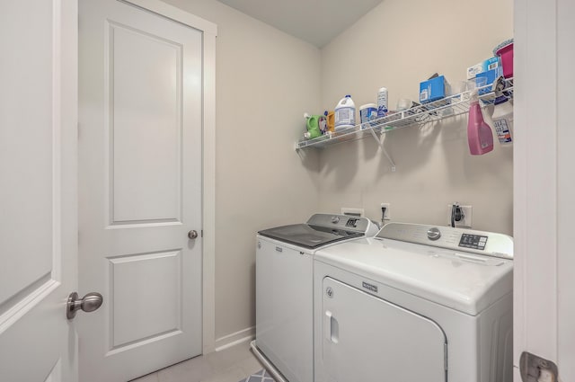 laundry room with laundry area, baseboards, and washer and clothes dryer