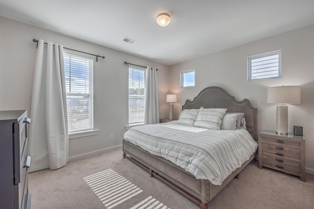 bedroom featuring visible vents, light carpet, and baseboards