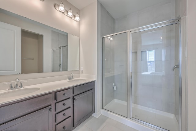 bathroom featuring double vanity, tile patterned floors, a sink, and a shower stall