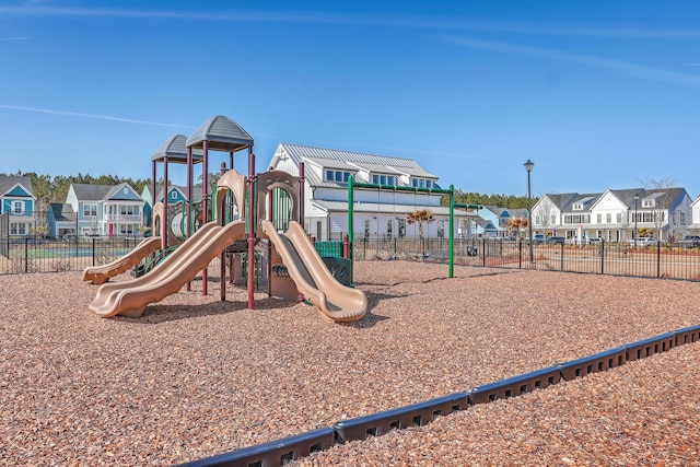 community play area featuring a residential view and fence