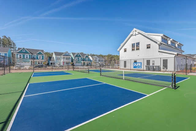 view of sport court with a residential view, community basketball court, and fence