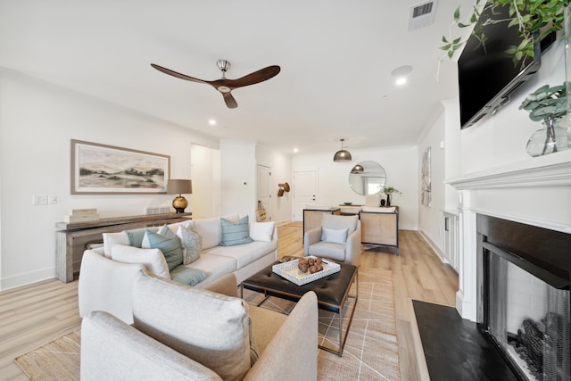 living room with light wood-type flooring and ceiling fan