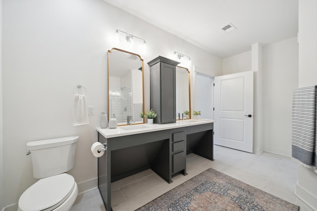 bathroom featuring vanity, toilet, tile patterned floors, and a shower