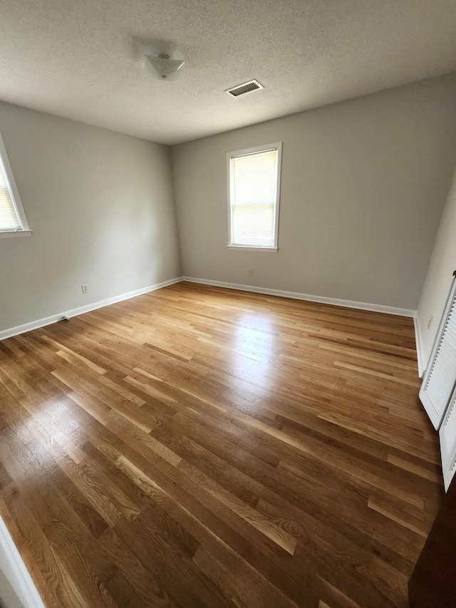 4029 Karen Dr, North Charleston, SC 29405 - empty room with healthy amount of natural light, wood finished floors, baseboards, and a textured ceiling
