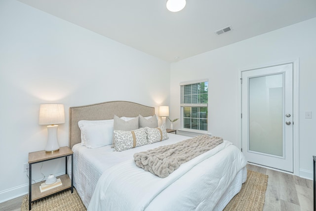 bedroom featuring baseboards, visible vents, and wood finished floors