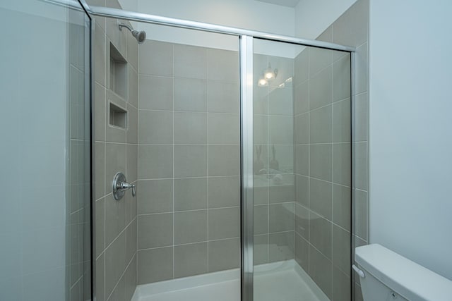 full bathroom with a stall shower and toilet