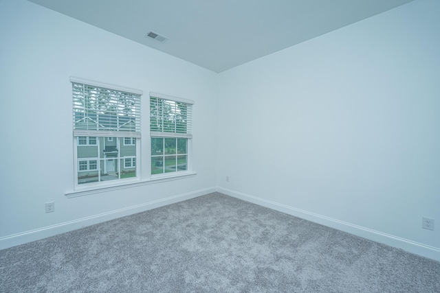 carpeted empty room featuring visible vents and baseboards