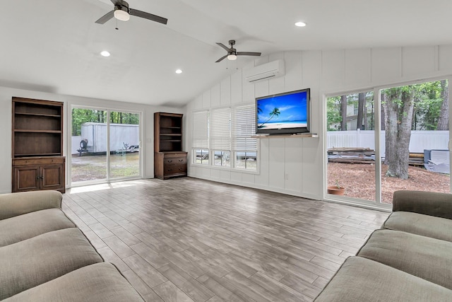living area with a wall mounted air conditioner, a ceiling fan, recessed lighting, wood finished floors, and vaulted ceiling