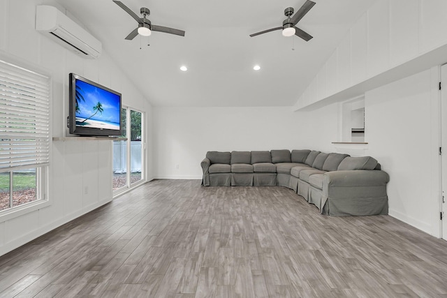 living area featuring a ceiling fan, a wall unit AC, and a healthy amount of sunlight