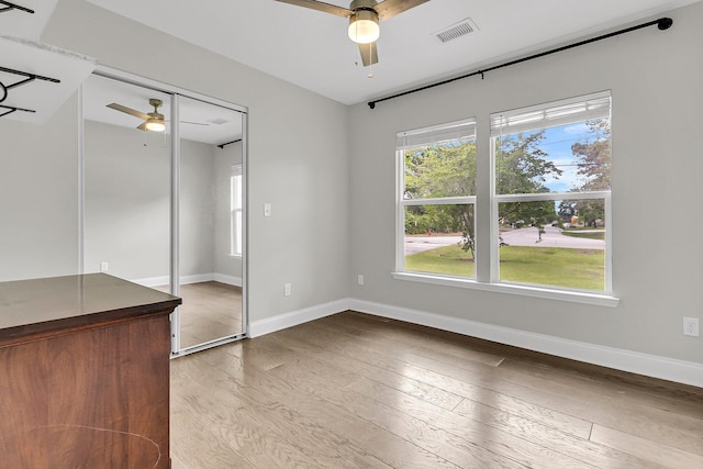 unfurnished bedroom with baseboards, visible vents, ceiling fan, and hardwood / wood-style flooring