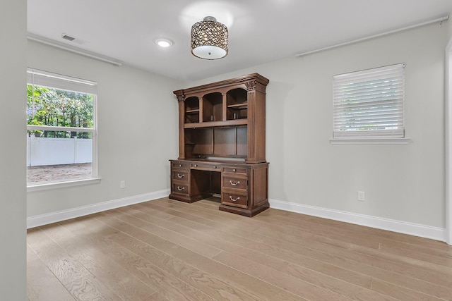 unfurnished office with baseboards, visible vents, and light wood-style floors