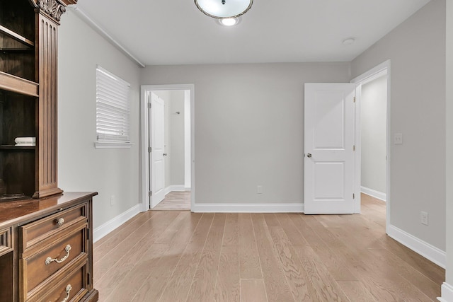 unfurnished bedroom featuring light wood-style floors and baseboards