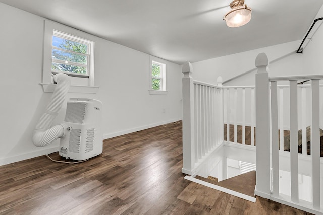 additional living space with baseboards, a wealth of natural light, and wood finished floors