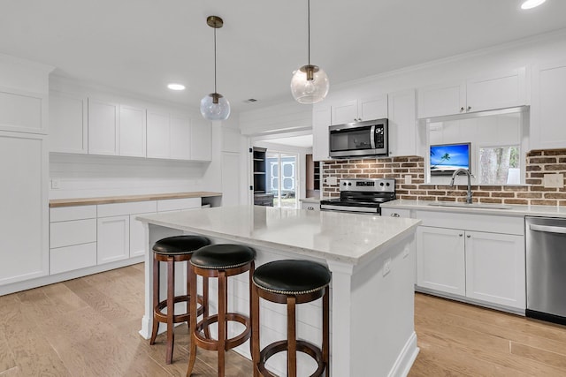 kitchen with crown molding, a sink, backsplash, and stainless steel appliances