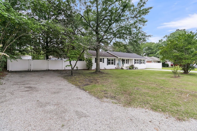 ranch-style house featuring fence, a gate, driveway, and a front yard
