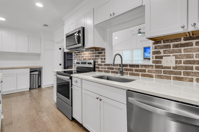 kitchen featuring white cabinets, ceiling fan, a sink, stainless steel appliances, and visible vents