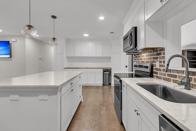 kitchen with a sink, light wood-style flooring, stainless steel appliances, recessed lighting, and backsplash