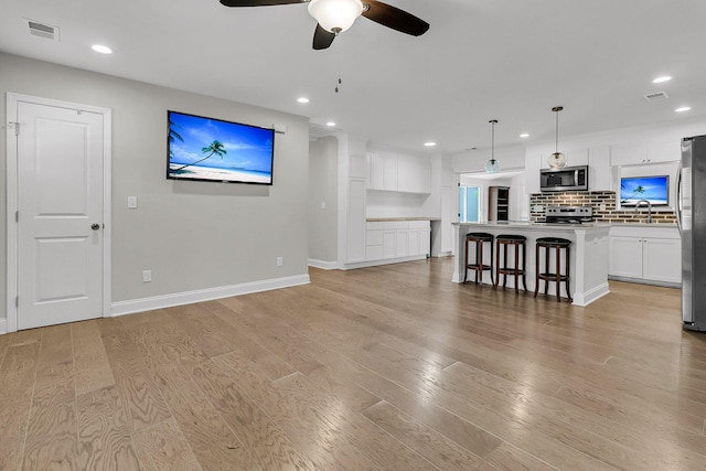 living room featuring visible vents, recessed lighting, light wood-style floors, and ceiling fan